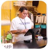 Laundromat employee looking at a tablet