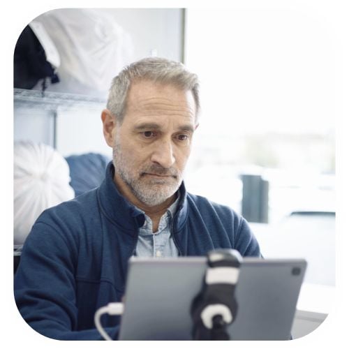 A picture of a laundromat owner looking at their tablet