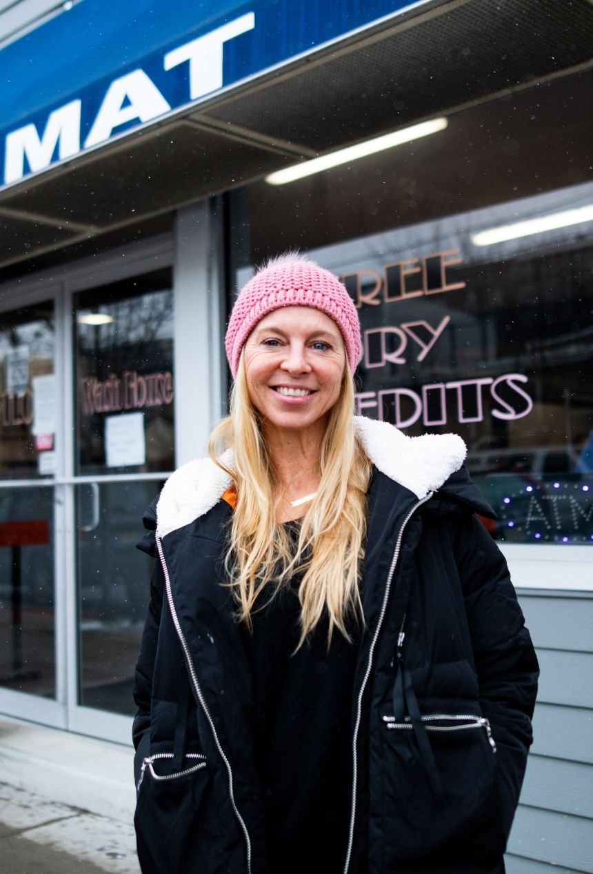 A picture of Tracy, owner of TLC Wash House, in front of her laundromat